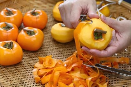 stock-photo-how-to-make-japanese-dried-persimmons-hoshigaki-peeling-a-persimmon-1852146319(1).jpg